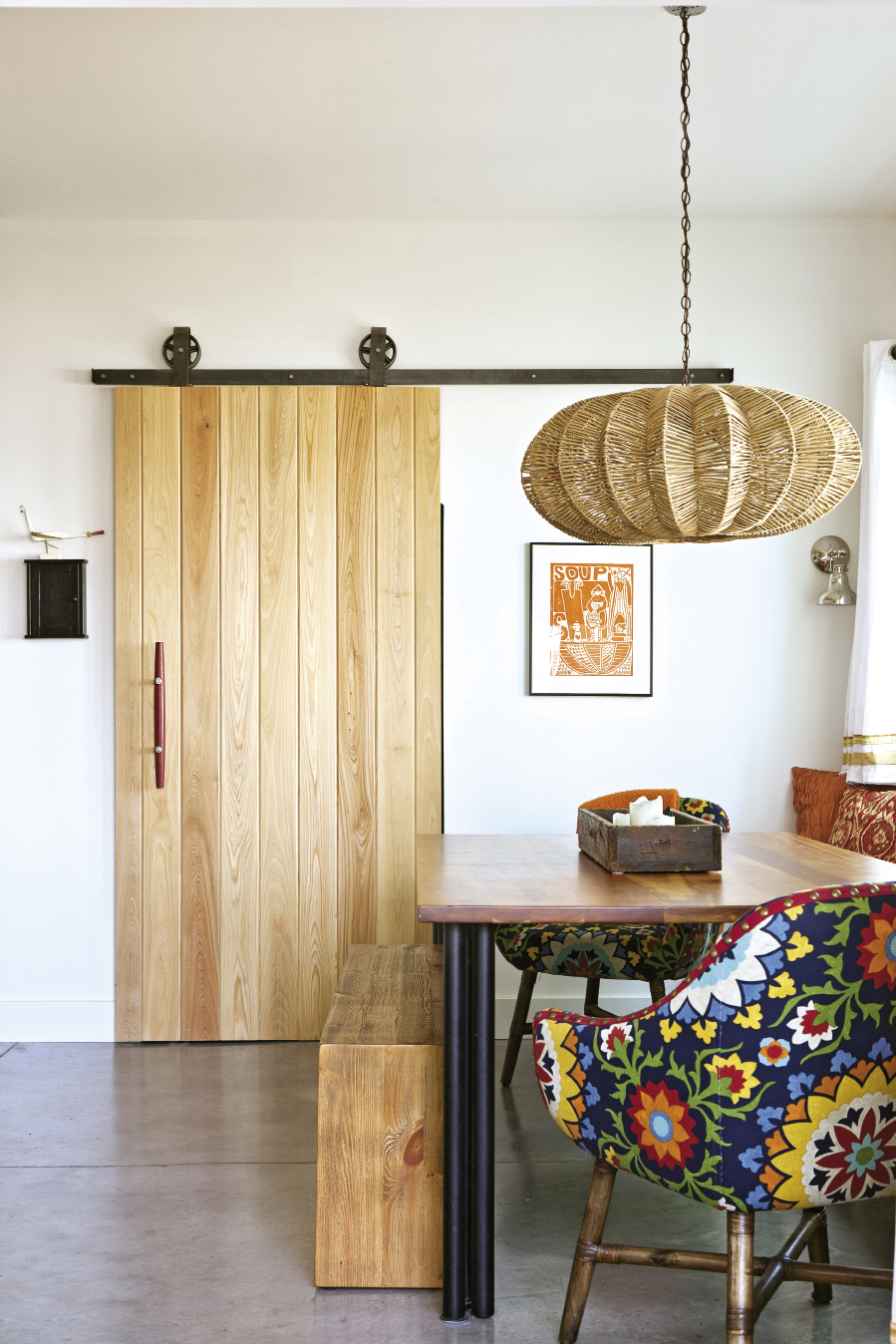 In the dining nook, a space-saving built-in bench pairs with chairs upholstered in funky fabric.