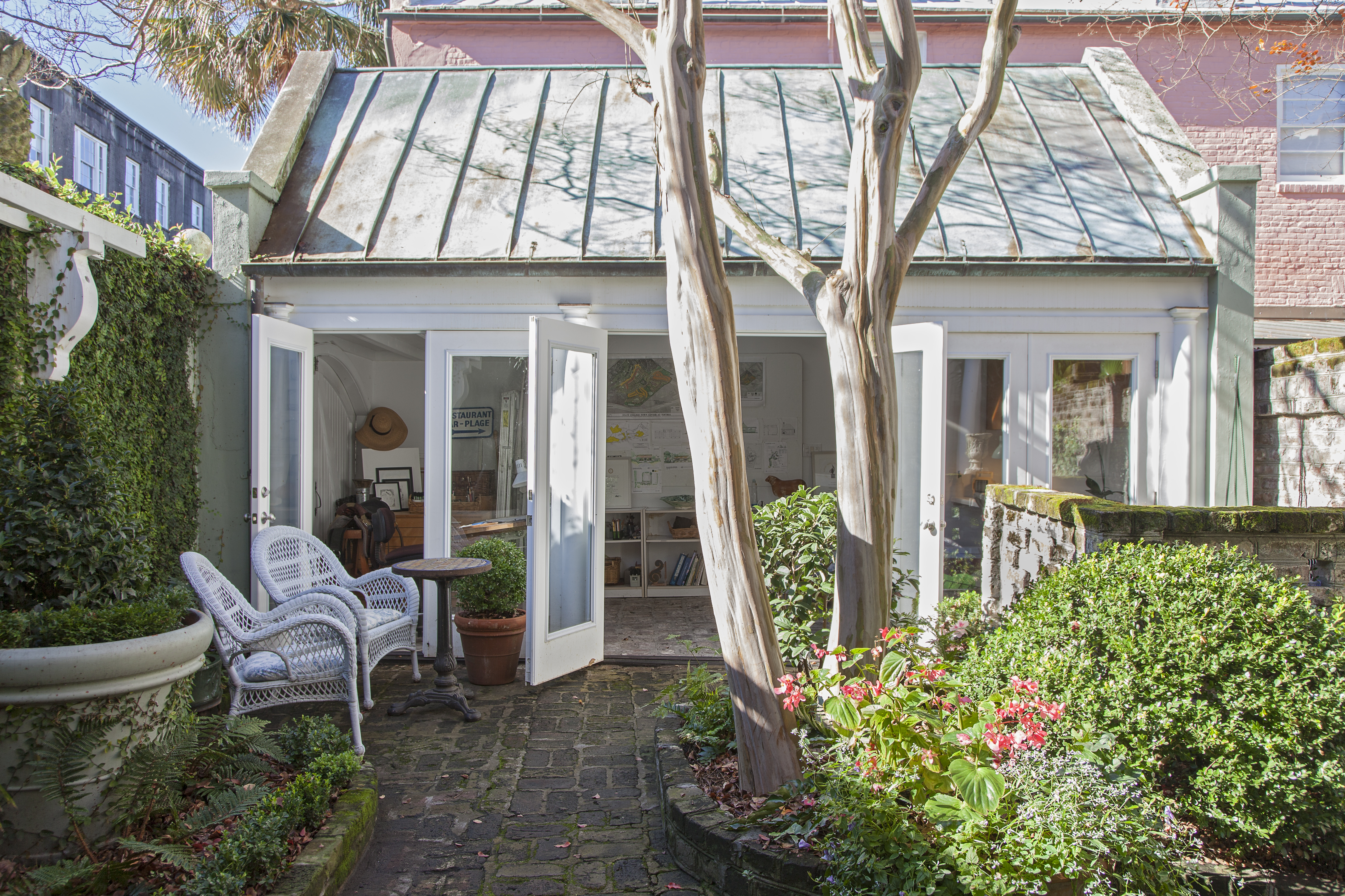 When she moved in, she added curved beds and a pierced brick partition to hide the AC unit.