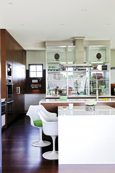 Modern Family: The kitchen features wenge cabinetry, high-gloss Caesarstone countertops, and Saarinen-inspired tulip armchairs.