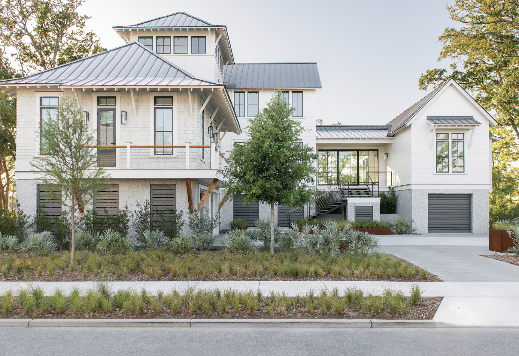 New Perspective: An empty marshfront lot in a new neighborhood on the just-developed Captain’s Island gave the Cuoco family the perfect opportunity to start over, embrace their passions, and create a space for the next stage of their lives. The resulting home eschews the traditional architecture and lush green lawns of its nearby neighbors on Daniel Island. Its modular design is highlighted by a tower, floating staircase, and glass entryway nestled in a landscape of native grasses, shrubs, and trees.