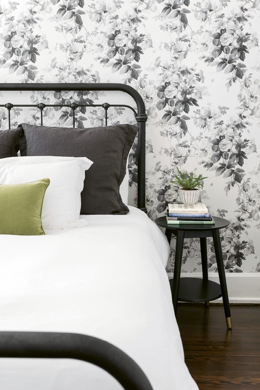 SWEET DREAMS - Alison’s mom visits often from Oklahoma, so a restful guest room was on the couple’s wish list. A metal spindle bed from Celadon, crisp white bed linens, and a vintage bedside table—all layered against House of Hackney’s “London Rose”-papered walls—delivers with aplomb.