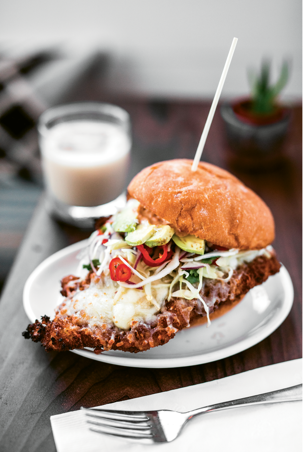Fried pork is paired with avocado and crunchy veggies on a torta.