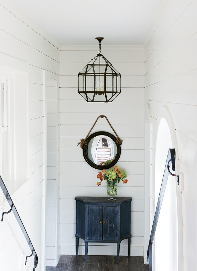Walk This Way: The steps leading to the second floor are original to the circa-1856 house; a third story was added in the earlier part of the 20th century. Peake painted the stairwell walls white and hung a convex mirror on the first landing to amplify the light.