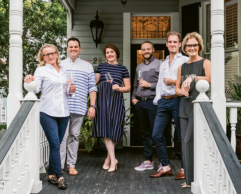 Before dinner, Trudi Wagner (far left) and Patty Floersheimer (far right) greet guests with glasses of rosé on the porch of their downtown home.