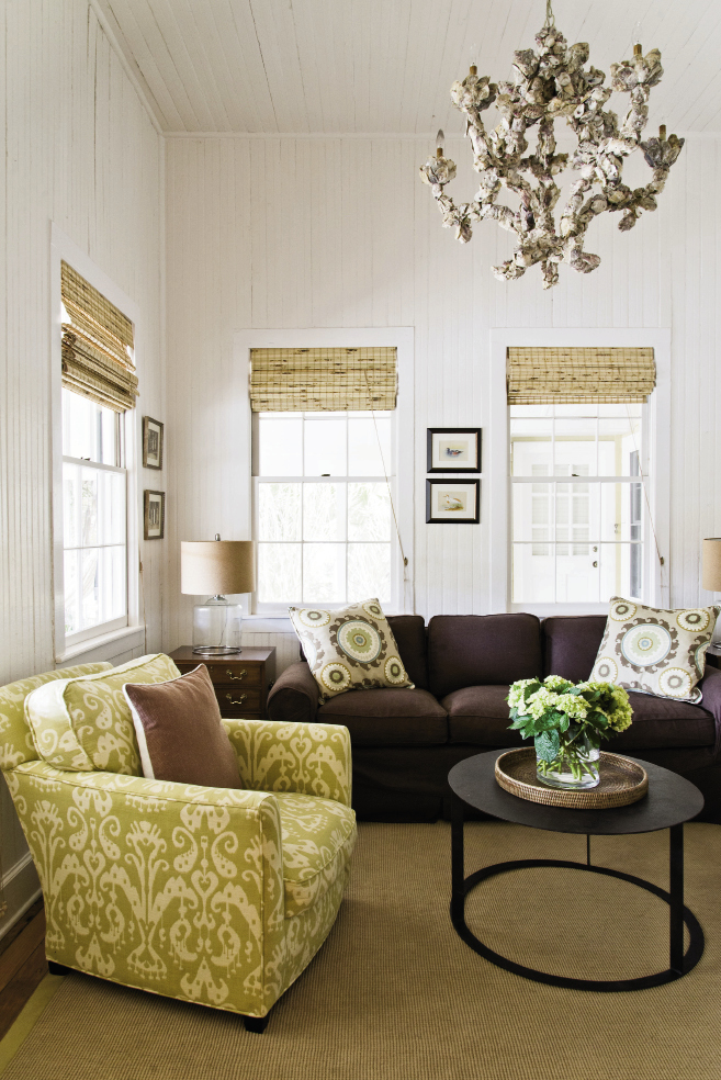 room service: A petite sitting room just inside the front door functions as a den. The sofa was re-covered with a no-fuss chocolate-hued slipcover, the table is from GDC, and the oyster shell chandelier was reused from Jenny’s old house.