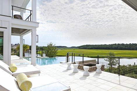 Marsh Living: The broad second-floor terrace faces Daniel Island’s Ralston Creek. The pair of double loungers are upholstered in Sunbrella fabric.
