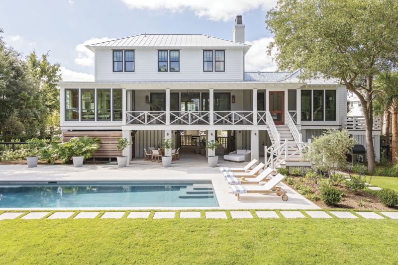 PARTY READY: When the family gathers, they spend time together not just in the house, but beneath it, too. The outdoor living room with a wood-burning fireplace and TV is an ideal spot for watching sports between dips in the pool. A wood-paneled outdoor shower and yard full of native flora complete the oasis.