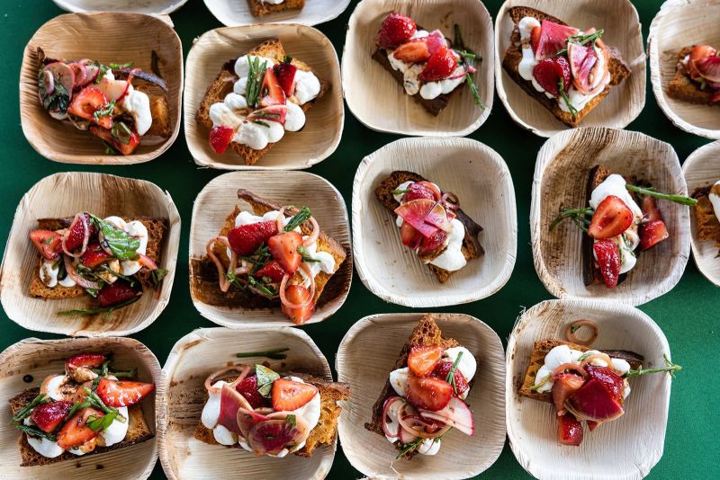 Compostable plates containing samples of strawberry bruschetta from Indaco chef Mark Bolchoz Jr.