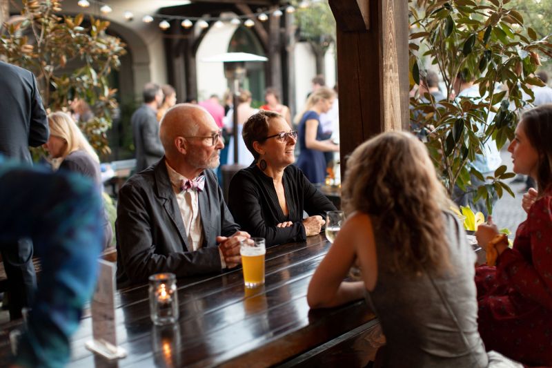 Supporters mingle over apps and drinks in the Edmund’s Oast courtyard.