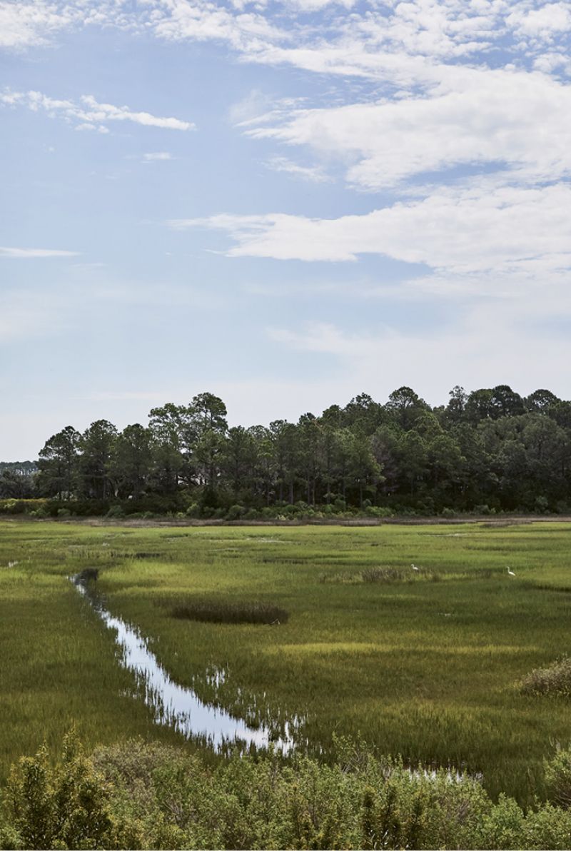 With a lot overlooking a tidal creek as well as the private community’s Tom Watson-designed golf course, the couple wanted the focus to be on the outdoors. “It’s such a beautiful setting,” says the mother. “We watch folks fly-fishing, wildlife in the marsh, and golfers on the greens. It’s all so very relaxing.”