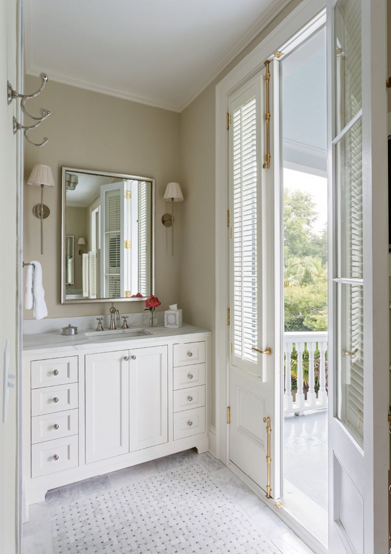 SOAK IN THE VIEW: The downsized master bathroom prioritized access to the piazza over soaking space (there’s no tub), keeping clean lines along with classic marble touches thanks to “Melissa Wall” sconces by Urban Electric and a Calacatta basketweave tile floor.