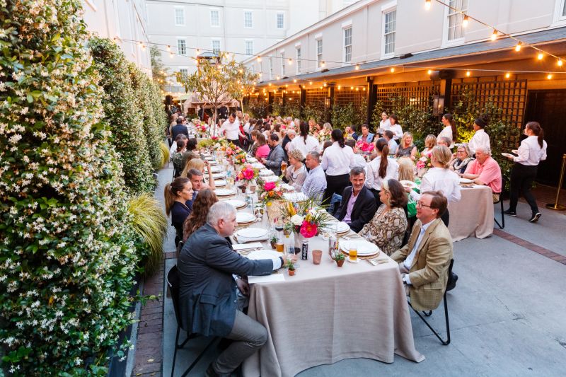 Guests gathered around long tables for The Assembly in Emeline’s greenhouse.