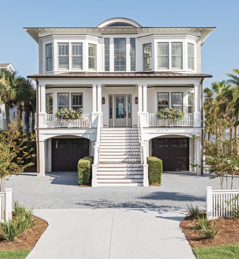 RIGHT AT HOME: Last summer, San Diego residents Tom and Amy Leonard—along with their three sons, as well as wheaten terriers Charlie and Oliver—made this oceanfront Isle of Palms house their second home. Fresh exterior paint and a total overhaul of the yard and hardscape perked up the property’s curb appeal. Relocating the driveway gave the home symmetry, while adding a pair of window boxes and painting the porch ceiling a pale blue upped its Lowcountry charm.