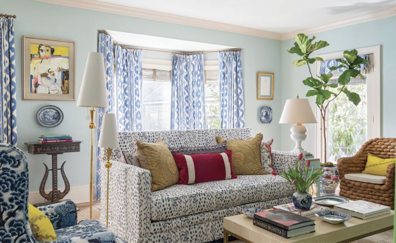 Into the Blue: Working with much of the client’s own furniture, Ralph leaned into the “blue room” theme in the family room, adding pinks and yellows to tie into the other spaces on the main floor. Inspired by, and replete with, plenty of chinoiserie, from blue and white china to the bold blue Quadrille “Bali Hai” curtains, the room also mixes in contemporary touches, such as the Jonathan Adler floor lamp and abstract figurative art by Charleston artist Anne Darby Parker.