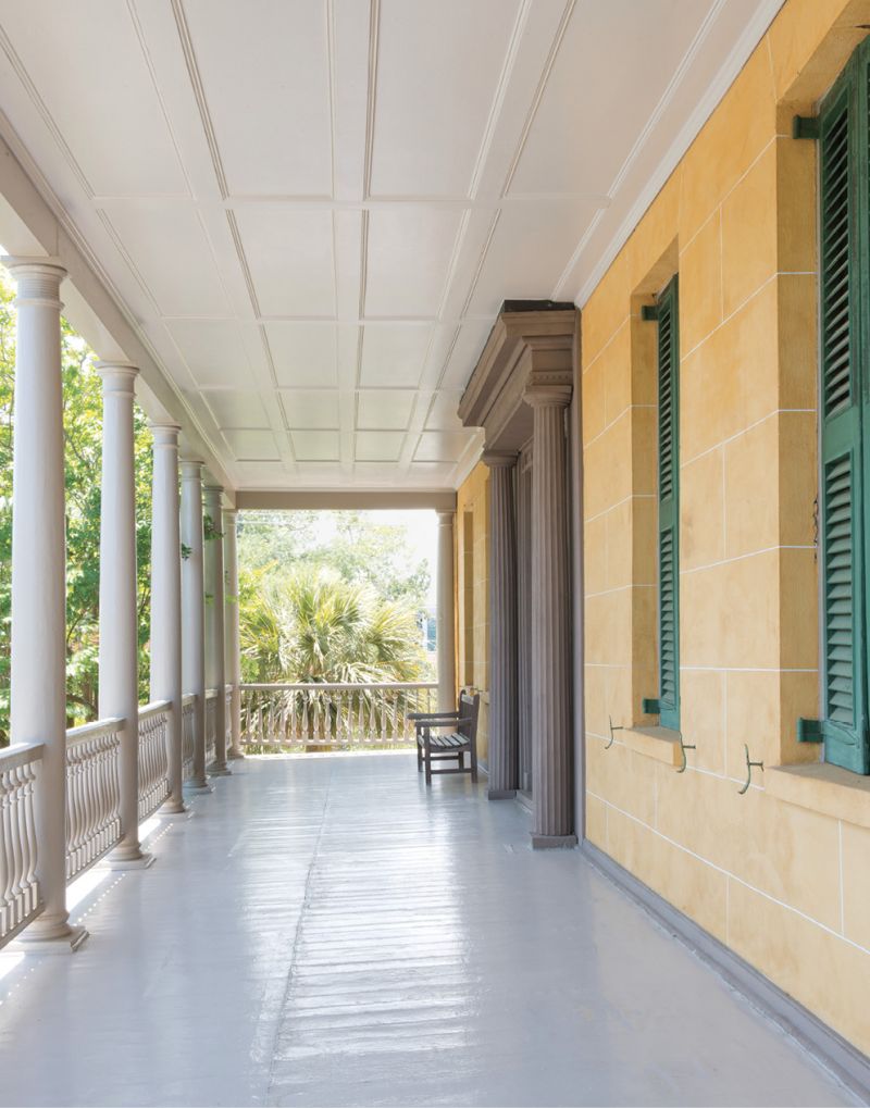 At the Aiken-Rhett House, stucco resembling masonry blocks and a monumental Greek Revival door surround give the piazza a majestic air.