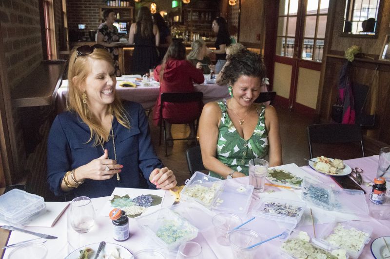 Meredith Siemens and Katie Strumpf share a laugh as they craft their designs.