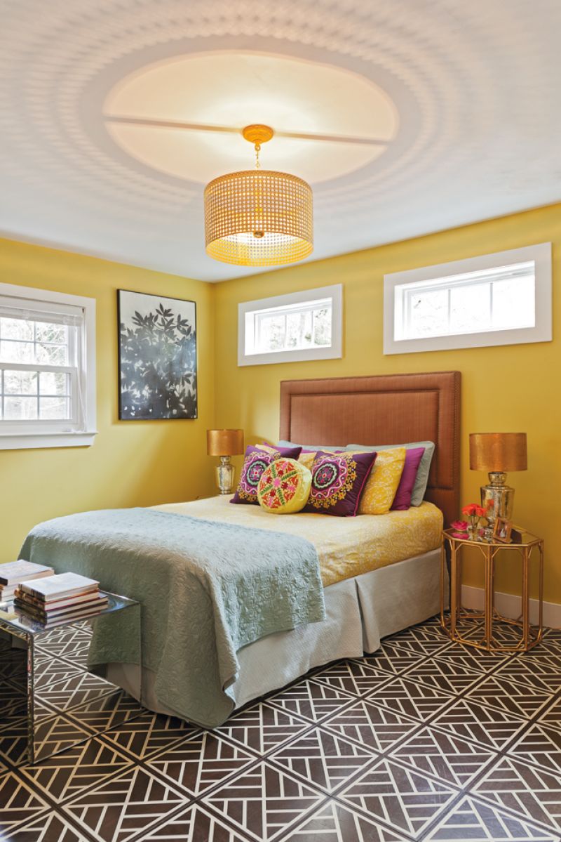 clean lines  For the master, Sally wanted a dark floor but designed the “Peninsula” tile with “a busy, globally inspired pattern that helps to keep it looking clean,” she says. The chandelier and headboard are local finds from Ro Sham Beaux and Taylor Burke Home, respectively.