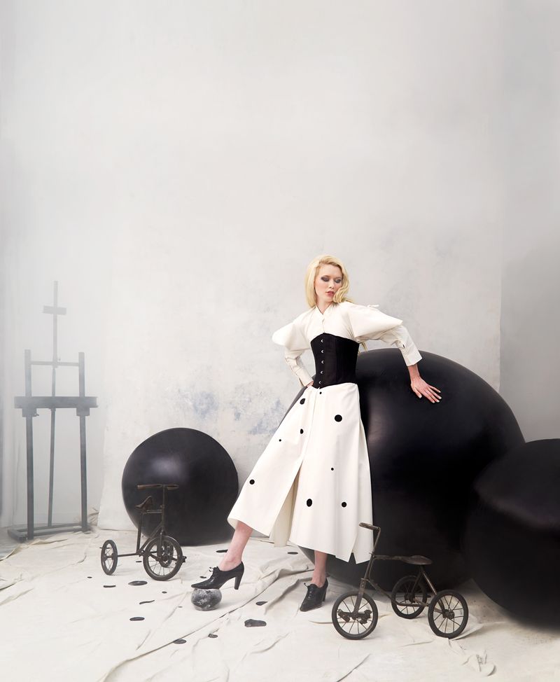 Find the Fun: Ashlyn cotton dress, $1,080 at RTW; polka dots, corset, and Stuart Weitzman shoes, stylist’s own; props courtesy of (vintage French tricycles) Alexandra AD; (easel) Dare Gallery