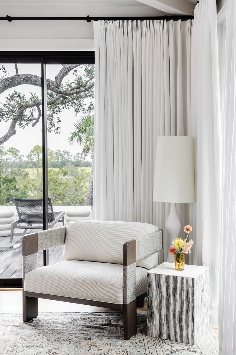 A Palecek chair serves as a cozy reading nook.