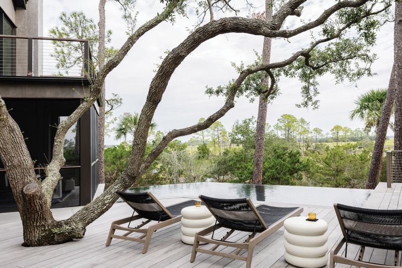 The original 1990s structure was completely renovated and a 600-square-foot wing added to the 2,900-square-foot home, encompassing a primary bedroom suite with sweeping views of the marsh over a new deck and pool.