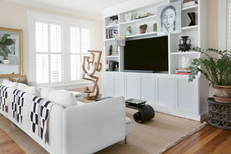 Serene Scene: An open family room, kitchen, and casual dining space comprise the first floor of the addition, where the Browns worked with CDS Restoration to build custom cabinetry; The metal sculpture in the family room is by South Carolina sculptor Jordan Fowler, and a Zhang Xiaogang work hung on the cabinet is a piece Debbie bought while vacationing in Beijing.