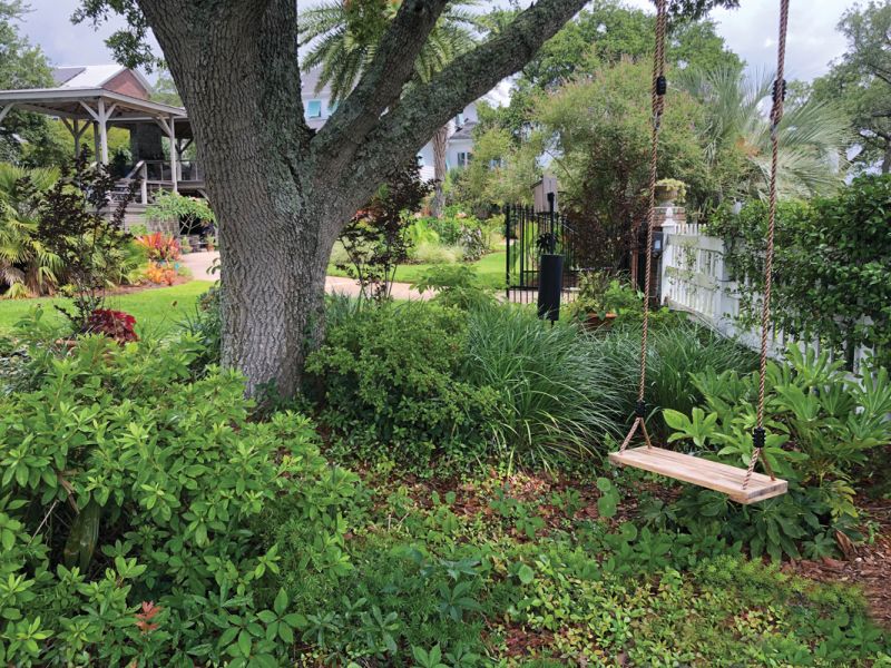 Sweet Spots: With poor soil, the bed near the marsh is tricky, says Bunny, but azaleas, giant liriope, fatsia, and star jasmine create a pretty swinging spot for visiting granddaughters.