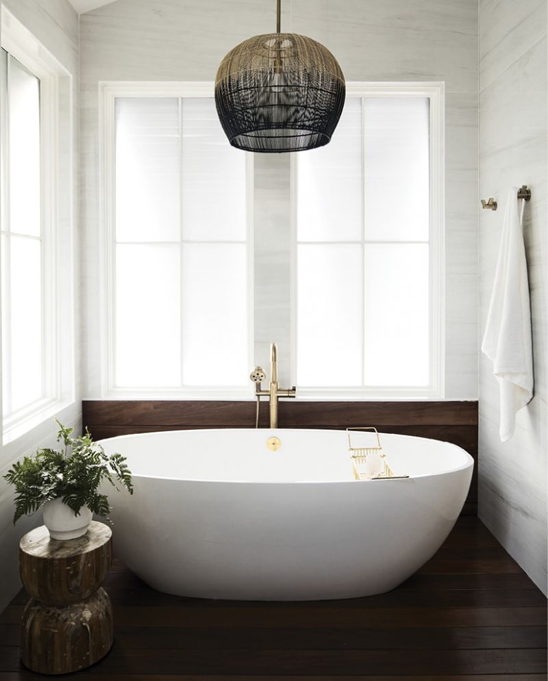An ombre rattan light fixture tops off the master bath wet room, which features a walk-in shower and freestanding tub, marble tile, and Ipe flooring.