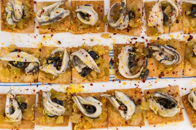 White Anchovy, Green Tomato Agrodolce with squid ink aioli, lavash, and cured egg yolk, prepared by Michael Holler of Indaco