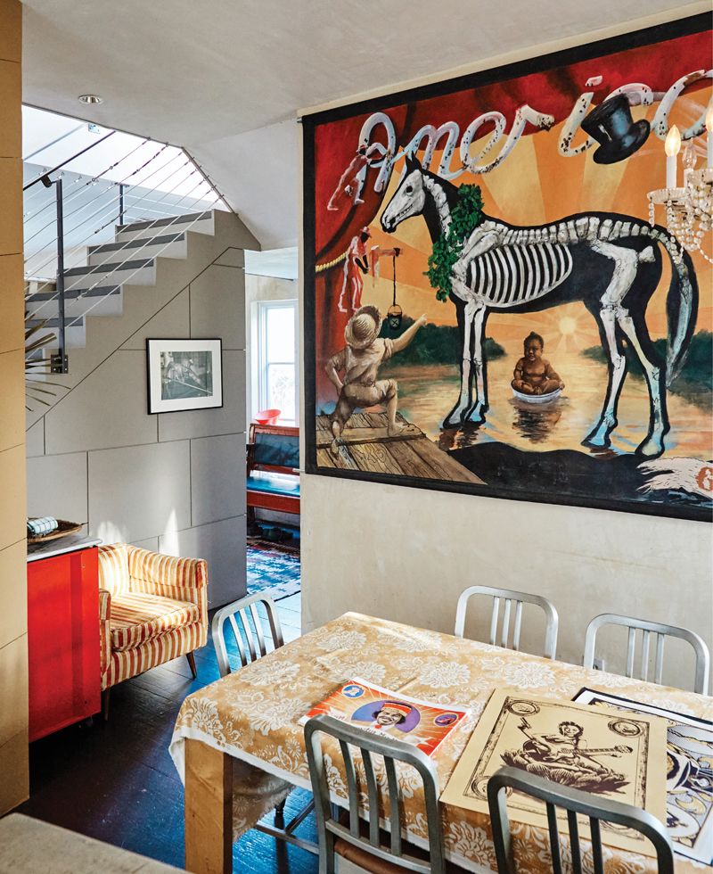His house also functions as a gallery. At right, his painting America, Good Luck (acrylic on canvas, 6 x 9 feet, 2018)