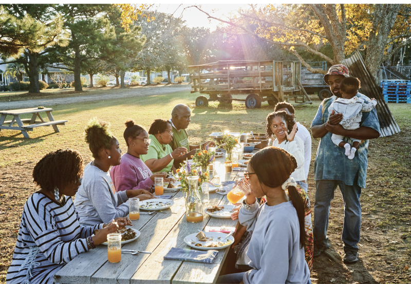 Gather Round: Dennis’s family and friends, including hosts Helen and Joseph Fields (in green), dig into the feast.
