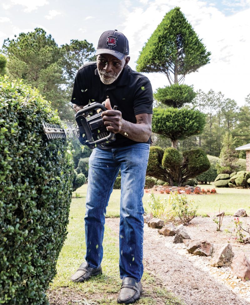 IN SHAPE: Wielding his hedge trimmer, Fryar demonstrates his craft of creating living sculptures. The “fish bone” towering in the distance was fashioned from a Leyland cypress that he planted just after Hurricane Hugo in 1989.