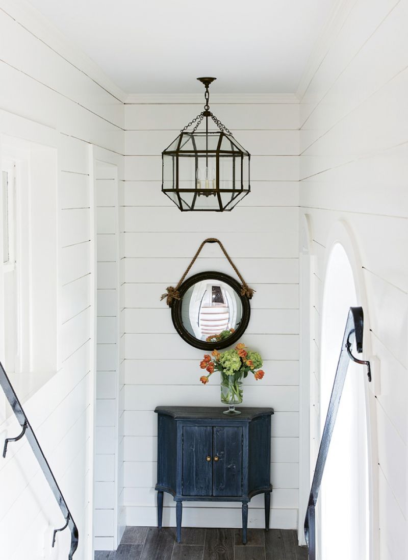 Walk This Way: The steps leading to the second floor are original to the circa-1856 house; a third story was added in the earlier part of the 20th century. Peake painted the stairwell walls white and hung a convex mirror on the first landing to amplify the light.