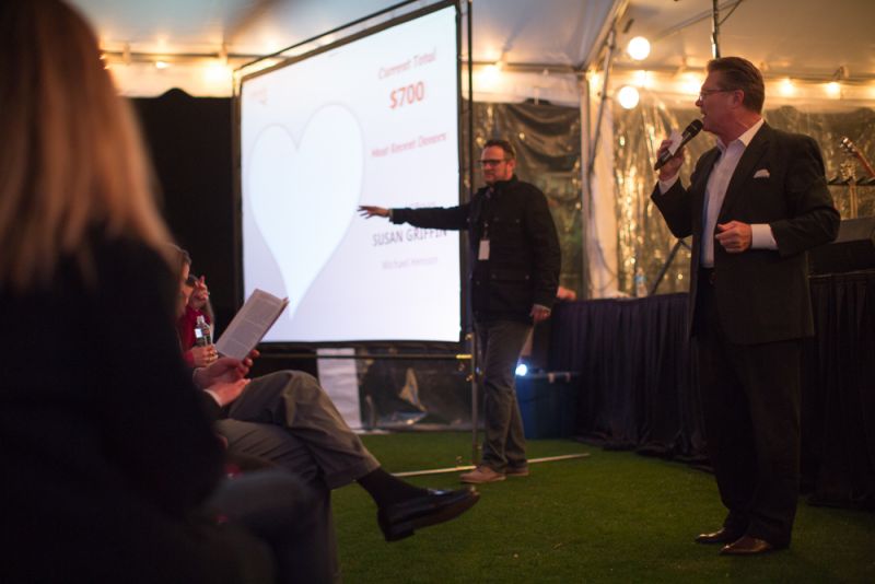 The auctioneer starts the bidding for a trip for two with St. Louis quarterbacks Case Keenum and Austin Davis.