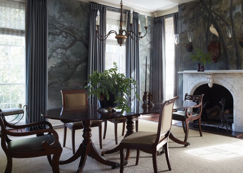 Moonlight In the Marsh: An original marble mantelpiece in the dining room pops against the dramatic custom mural by Atlanta-based artist Raymond Goins. Painted on burlap panels, the moody Lowcountry scene is illuminated during the day by light from the large windows at the front of the house.