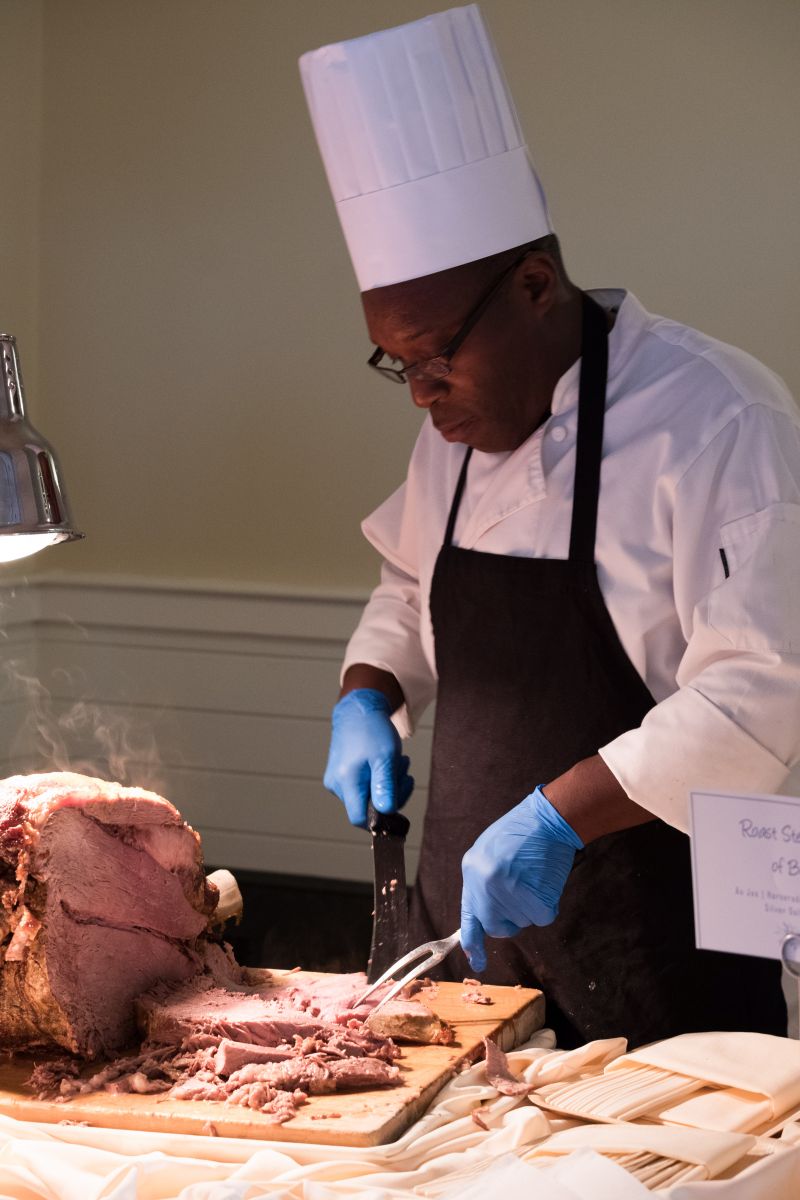 A chef prepares roast beef for sliders.