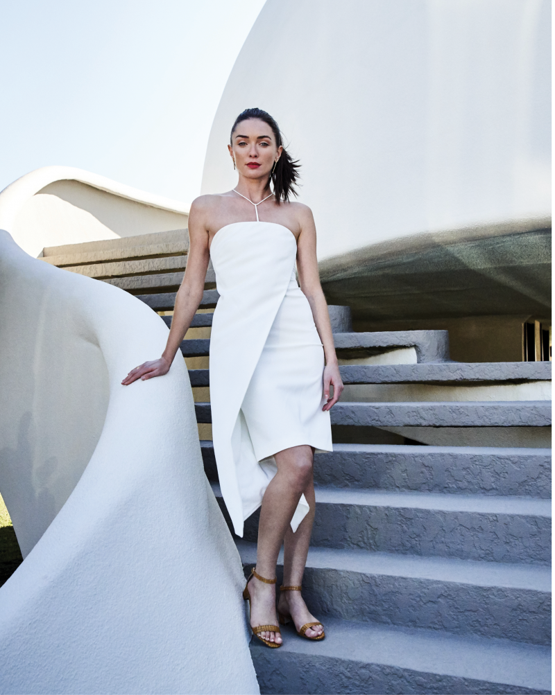 A STEP AHEAD - Milly “Kendall” asymmetrical dress in Italian cady, $495 at milly.com; Manolo Blahnik “Chaflahi” raffia sandal, price upon request at RTW; Christina Jervey 14K gold-plate “Mismatched Stick” earrings, $150 at Gwynn’s of Mount Pleasant