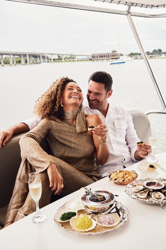<b>Caviar Dreams: </b>(On Krystina) St. John metallic voile blouse, $795, and pants, $995, both at St. John Knits; Romero Hecho a Mano “Aguaibay” earrings, $185 at Lesetta; Capucine De Wulf “Cleopatra” bangle, $145 at Juliska; 14K-gold link bracelet, $3,425, and Jude Frances “Moroccan Marrakesh” turquoise ring, $2,850, both at Croghan’s Jewel Box; David Yurman 18K “Cable Edge Saddle Ring” with pavé diamonds, $5,500 at Reeds; (On Nikolas) Ike Behar “Havana ’32” linen sport shirt, $265 at Ike Behar; (Props) Baccarat flutes, Michael Aram caviar dish and spoon, and Champagne bucket, all from Gwynn’s of Mount Pleasant; Osetra caviar and oysters from Harvest Catering.