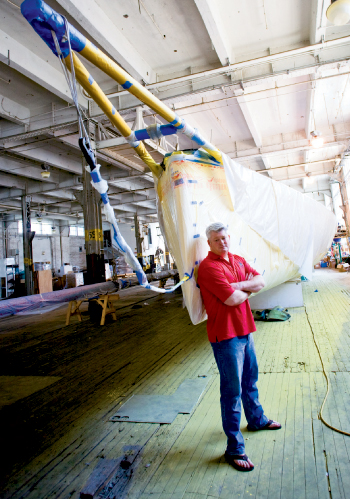 In a North Charleston warehouse, the boat is stripped, sanded, and painted. The crew will also outfit the vessel with new hardware, electronics, wiring, and sails. Photograph by Kaitlyn Iserman.